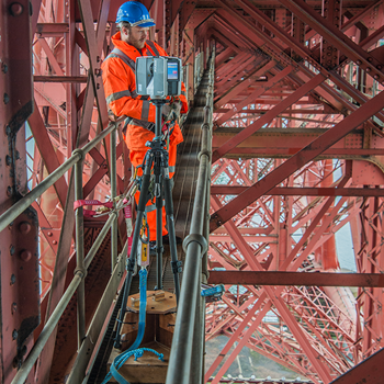 A person in a hard hat and high vis overalls, laser scanning the Forth Bridge
