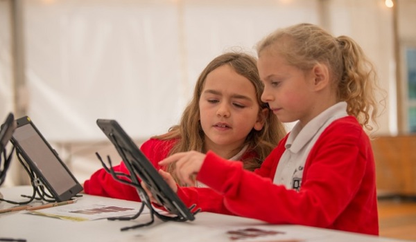 Two schoolchildren playing with ipads
